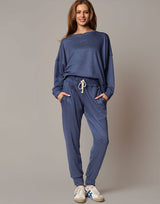 Woman wearing a blue tracksuit against a gray background