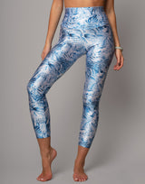 Person wearing blue and white patterned leggings on a gray background