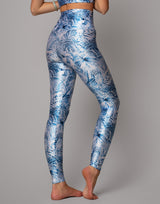 Person wearing blue floral leggings on a gray background