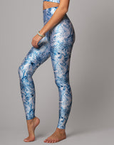 Person wearing blue floral leggings on a gray background