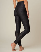 woman wearing chic black animal printed legging on grey background