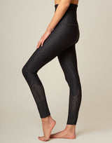 woman wearing chic black animal printed legging on grey background