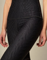 woman wearing chic black animal printed legging on grey background