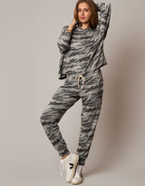 Woman wearing a camouflage outfit with a plain background