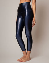 Person wearing shiny blue leggings on a neutral background
