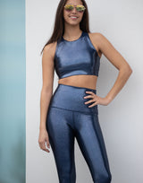 woman wearing high shine and sparkling navy colored legging on grey background