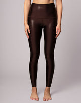 woman wearing high shine and sparkling chocolate brown colored legging on grey background