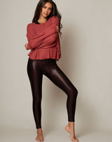 woman wearing oversized waffle knit long sleeve top in papaya red orange on grey background