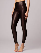 woman wearing high shine and sparkling chocolate brown colored legging on grey background