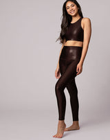 woman wearing high shine and sparkling chocolate brown colored crop top and legging on grey background