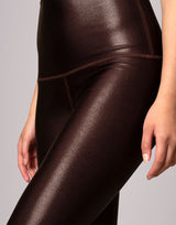 woman wearing high shine and sparkling chocolate brown colored legging on grey background