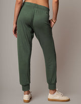 Person wearing green sweatpants on a plain background