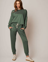 Woman wearing a green tracksuit against a plain background