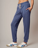 Blue jogger pants worn by a person on a plain background