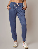 Blue jogger pants worn by a person on a plain background