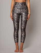 Person wearing animal print leggings on a plain background