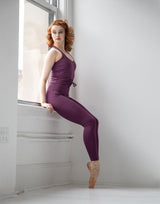 woman wearing eggplant purple colored tank top and leggings in a studio