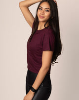 woman wearing burgundy t-shirt on grey background