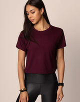 woman wearing burgundy t-shirt on grey background