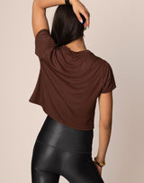 woman wearing chocolate brown colored t-shirt on grey background