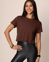 woman wearing chocolate brown colored t-shirt on grey background