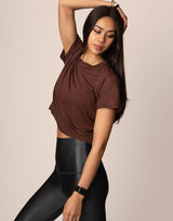 woman wearing chocolate brown colored t-shirt on grey background