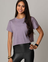 woman wearing lavender colored t-shirt on grey background