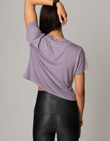 woman wearing lavender colored t-shirt on grey background