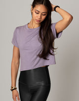 woman wearing lavender colored t-shirt on grey background
