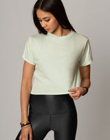 woman wearing mint colored t-shirt on grey background
