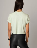 woman wearing mint colored t-shirt on grey background