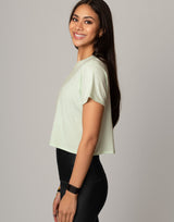 woman wearing mint colored t-shirt on grey background