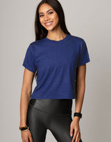 Woman wearing a blue t-shirt and black leggings on a gray background