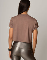 woman wearing toffee colored t-shirt on grey background