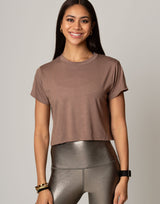 woman wearing toffee colored t-shirt on grey background