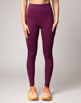 woman wearing violet legging with side pockets on grey background