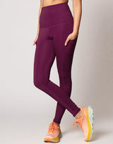 woman wearing violet legging with side pockets on grey background