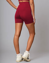 Person wearing red high-waisted shorts on a plain background