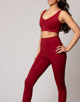 woman wearing v neck crop in cranberry red on grey background