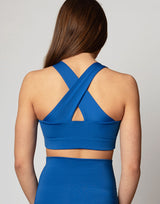 woman wearing crop top in azure blue on grey background