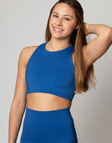 woman wearing crop top in azure blue on grey background