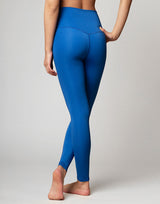 woman wearing azure blue colored legging on grey background