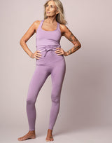 woman wearing legging and tank top set in lavender purple on grey background
