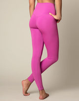 woman wearing orchid pink colored legging on grey background