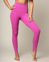 woman wearing orchid pink colored legging on grey background