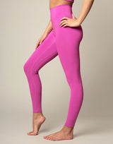 woman wearing orchid pink colored legging on grey background
