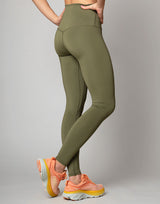 woman wearing moss green colored legging on grey background