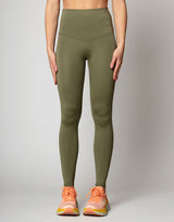 woman wearing moss green colored legging on grey background
