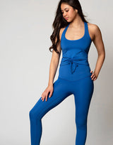 woman wearing azure blue colored legging on grey background