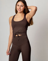 woman wearing chocolate brown colored tank top on grey background